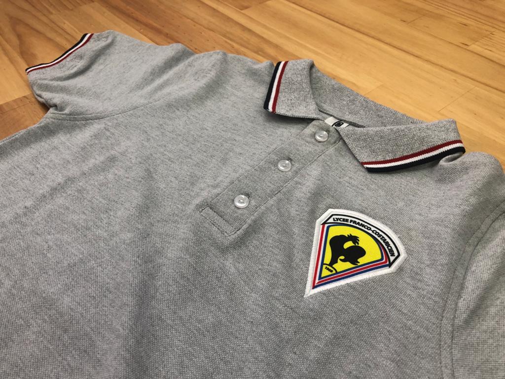 Uniforme escolar tipo polo gris con parche bordado de colegio