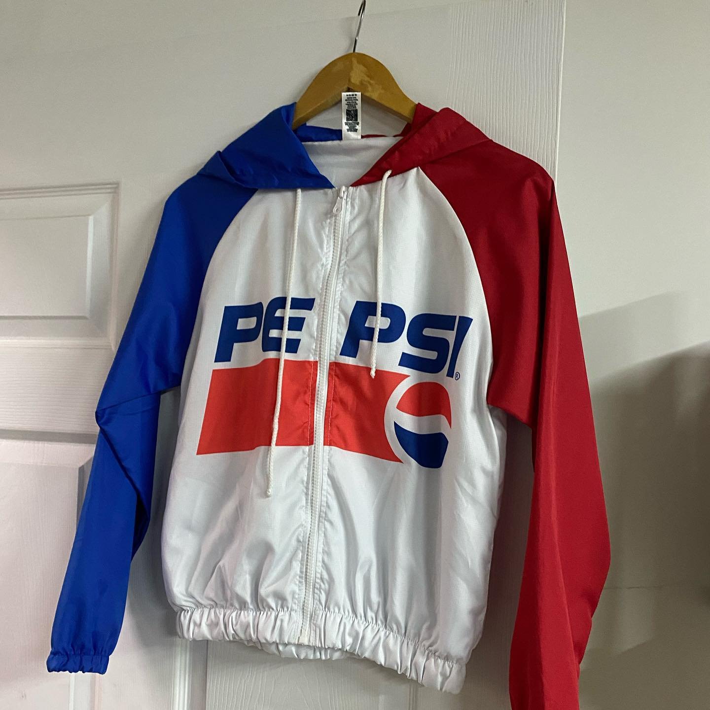 Jacket rompevientos Pepsi en azul, blanco y rojo, ejemplo de asesoría de color y marca