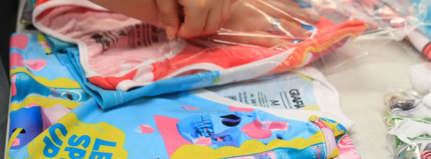 Camisetas GRAFIA siendo empacadas a mano en producción por volumen